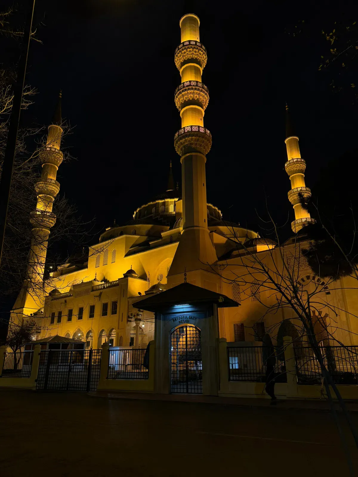 Ertuğrul Gazi Mosque in Ashgabat at night, illuminated by beautiful yellow architectural lighting, Turkmenistan