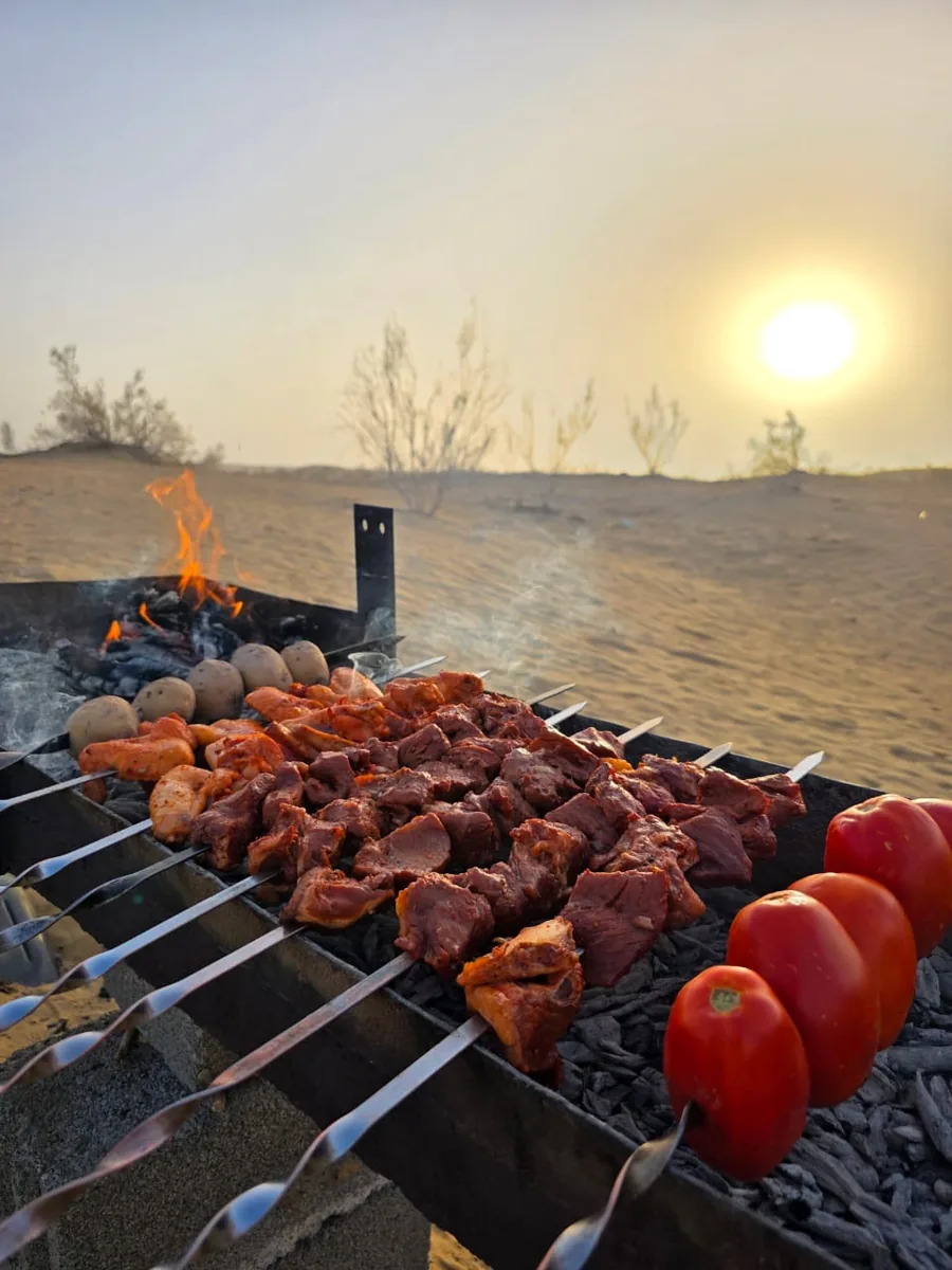 Shish kebab alla griglia nel deserto del Karakum al tramonto, Turkmenistan