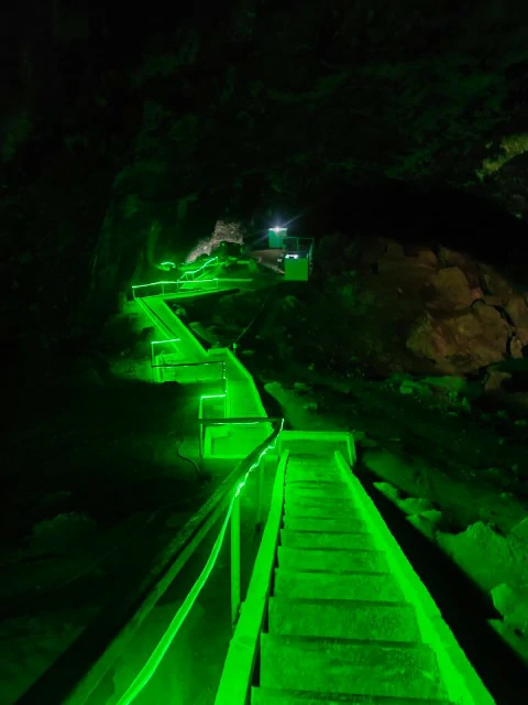 Lago sotterraneo di Kov-Ata in Turkmenistan, percorso illuminato da luce verde all'interno della grotta