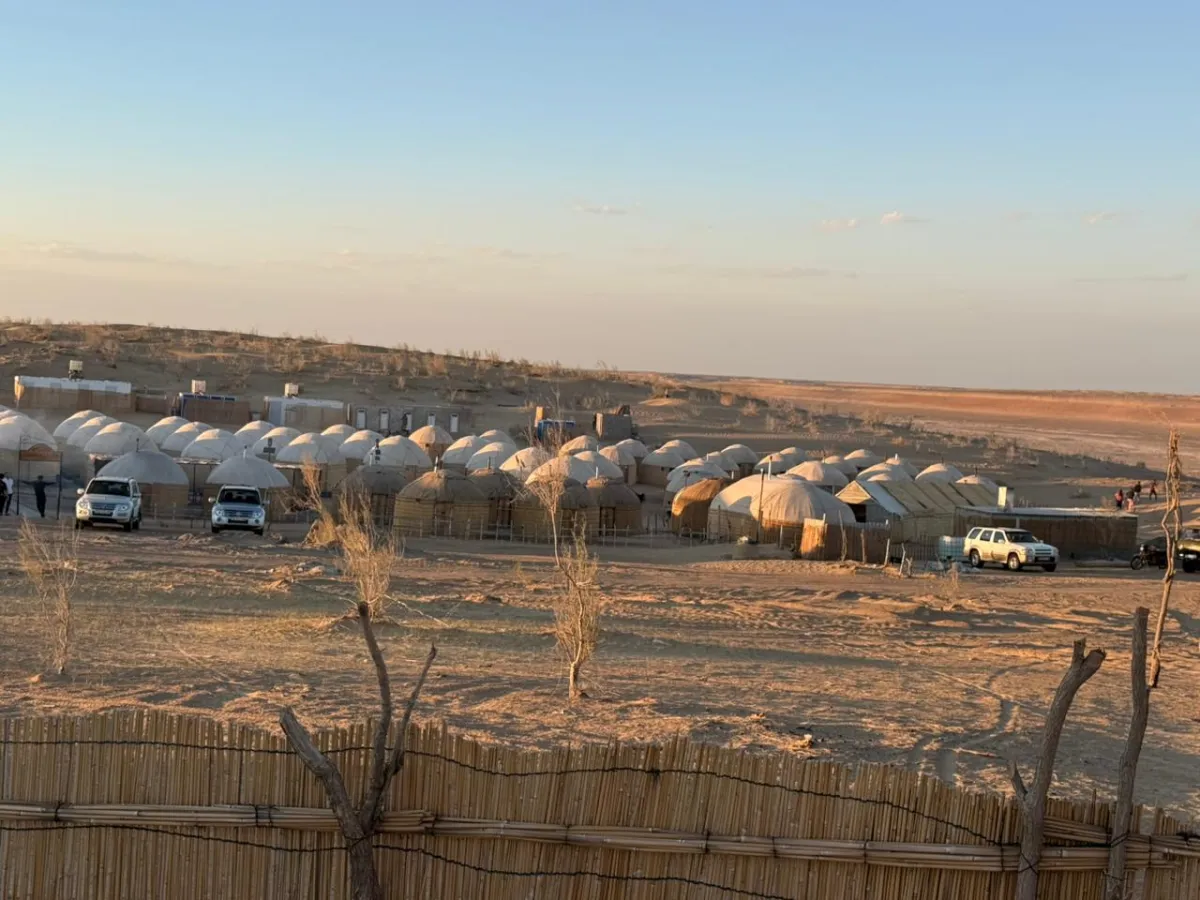 Traditional white yurts and off-road vehicles at an eco-camp in the middle of the Karakum Desert in Turkmenistan